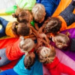 Cheerful children playing team building games on a floor